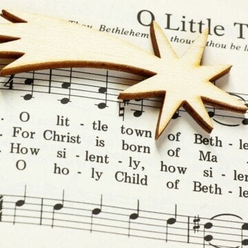A music score with clefs and text and a golden star laid on top of it