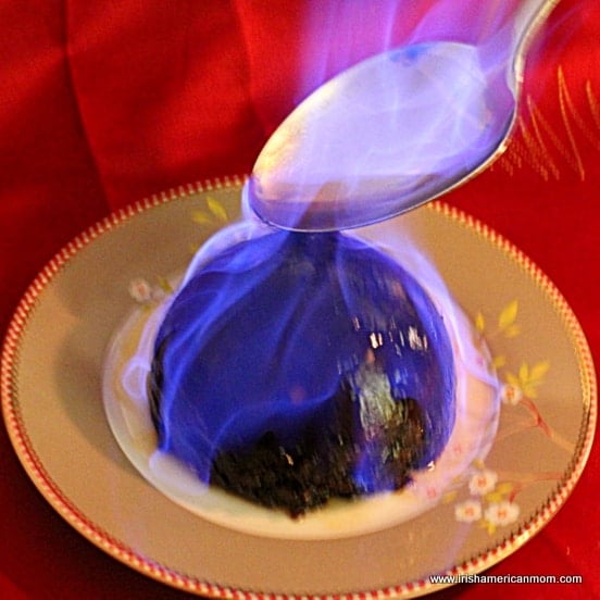 using a metal spoon of brandy to light a Christmas pudding