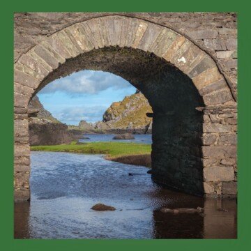 Arched bridge with mountain landscape showing under the archway