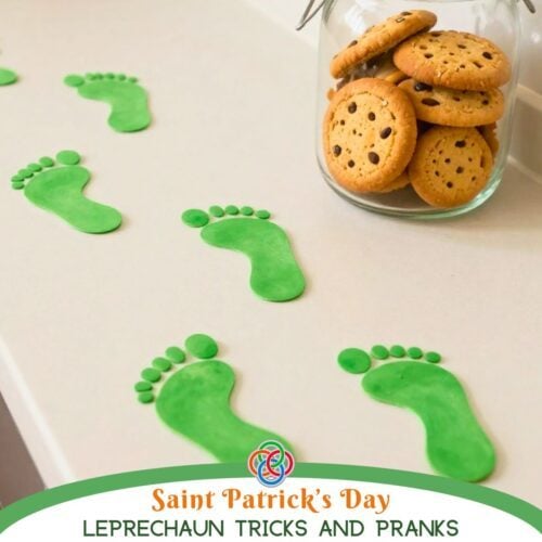 Green leprechaun footprints on a kitchen counter leading toward a jar of cookies, promoting St. Patrick's Day leprechaun tricks and pranks with Irish American Mom branding.