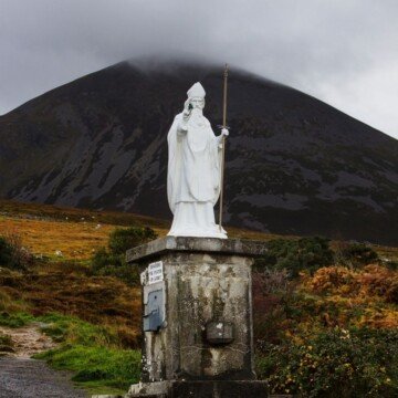 A white statue at the foot of a mountain