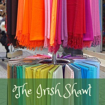 Shawls on a display rack with a text banner