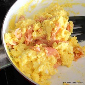 Mixing smoked salmon through scrambled eggs