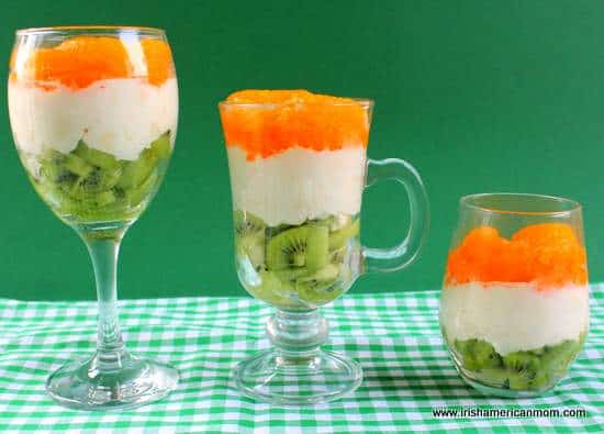 Three Irish flag fruit and cream parfait desserts standing in a row | Irish American Mom Three Irish flag fruit and cream parfait desserts standing in a row