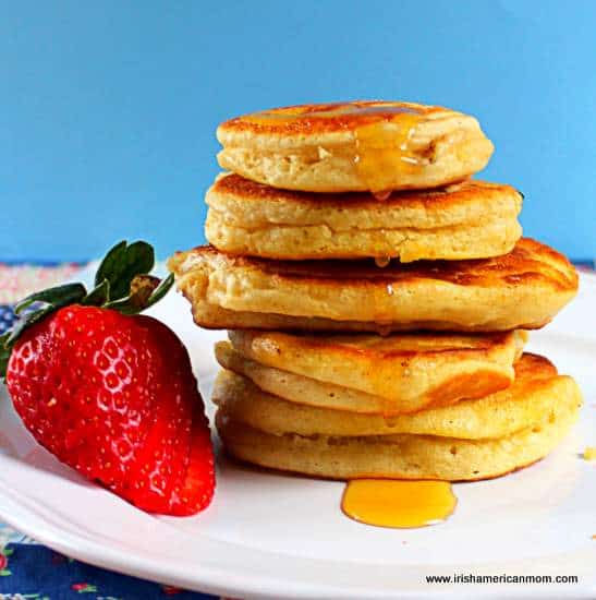 Irish buttermilk pancakes in a stack with honey dripping down the side