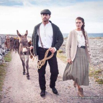 A man and woman leading a donkey on a road