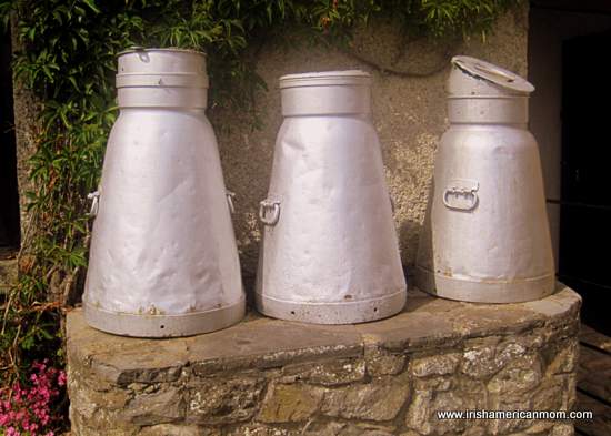 Three milk churns on a milk stand