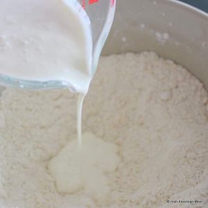 Buttermilk being added to flour to form dough for Irish buttermilk scones.