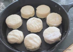 Uncooked scones being placed in a cast iron skillet