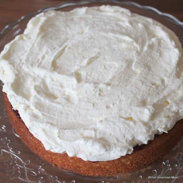 adding-a-layer-of-cream-to-a-victoria-englis-sponge-sandwich-cake | Irish American Mom spreading cream inside a sponge sandwich cake