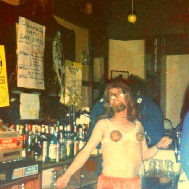 A person standing in front of a store and bar with liquor bottles