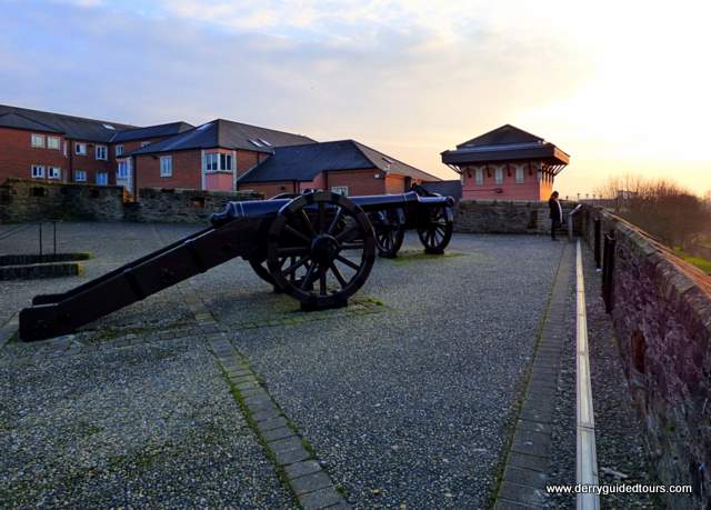 Cannon pointing out over old stone walls