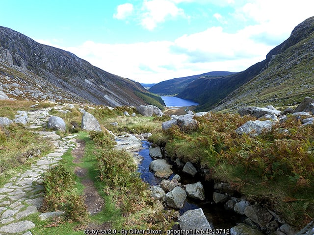 A rocky hill side with a stream 