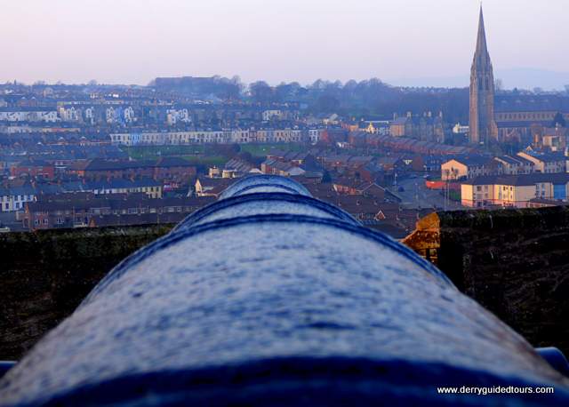 Looking out over a cannon toward distant buildings
