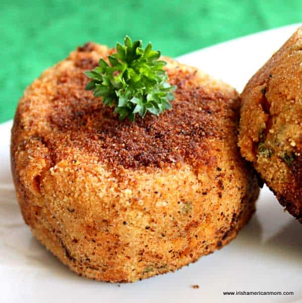 Salmon cake on a plate - made using canned or tinned salmon | Irish American Mom Salmon cakes with parley garnish on a white plate