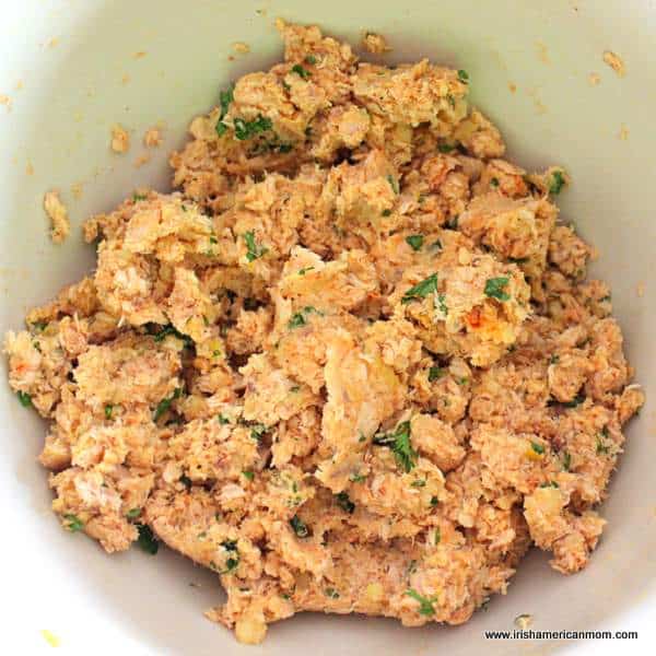 Salmon with parsley, mashed potato, and seasonings for salmon fish cakes | Irish American Mom Salmon mixture in a bowl