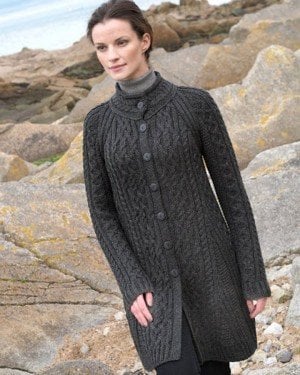 Long aran coat in slate gray from Standun Spiddal | Irish American Mom A person standing on a rocky shore