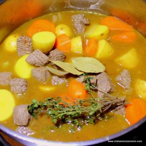 herbs in a pot of stew with meat, potatoes and carrots