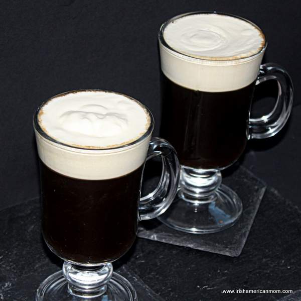 Two Irish coffees with floating cream | Irish American Mom Two glasses of Irish coffee with cream on top