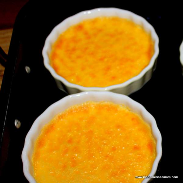 Creme brulee custard baked in the oven before adding a torched crispy sugar layer | Irish American Mom Yellow custards in ramekins