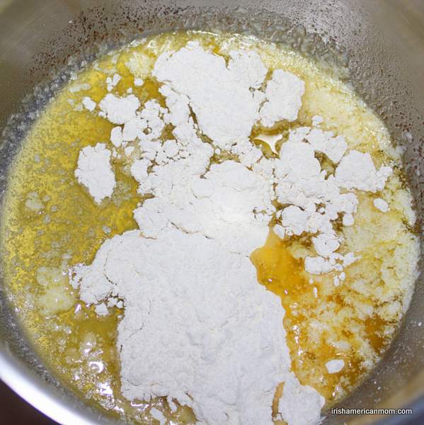 Adding flour to melted butter for a roux | Irish American Mom Adding flour to melted butter to make a roux.