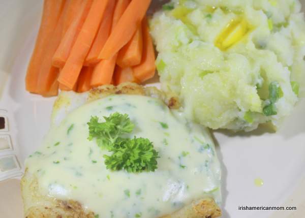 An Irish Dinner - cod and parsley sauce with champ | Irish American Mom A serving of cod and parsley sauce with potato champ and steamed carrot sticks.