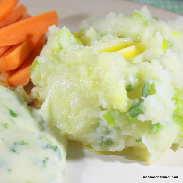 Champ - an Irish potato side dish | Irish American Mom A serving of potato champ beside carrots and cod with parsley sauce