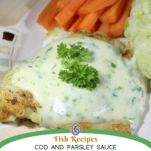 Flaky cod fillet topped with creamy parsley sauce and garnished with fresh parsley, served with carrots and vegetables on a plate.