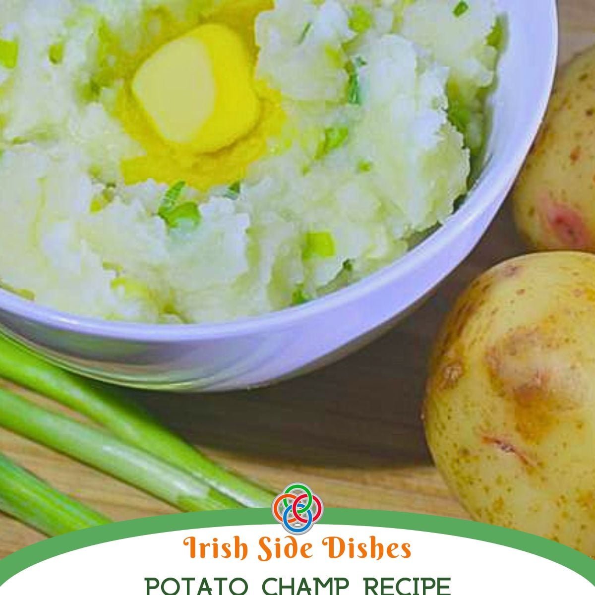 Bowl of potato champ with butter and chopped green onions, beside potatoes and scallions on a wooden surface; recipe title Irish Side Dishes Potato Champ.