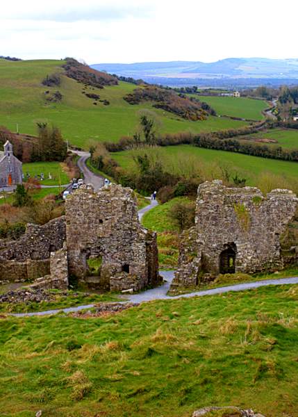 Castle ruins at the Rock of Dunamase in County Laois Ireland | Irish American Mom A ruined castle wall on a hill looking out over green fields toward mountains