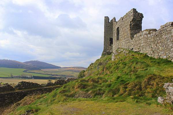 The castle walls on the Rock of Dunamase between Stradbally and Portlaoise in County Laois Ireland | Irish American Mom A large stone ruined building with a mountain in the background