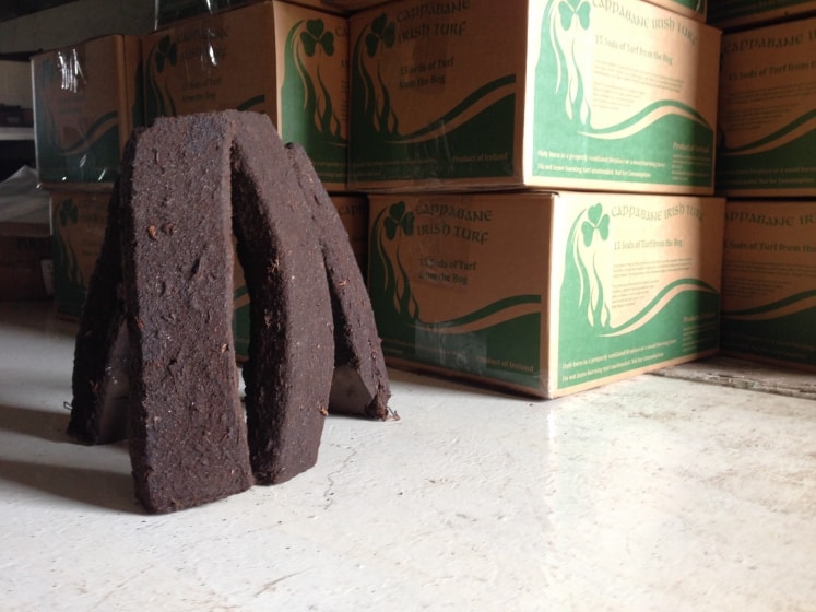 Peat or turf beside a stack of cardboard boxes