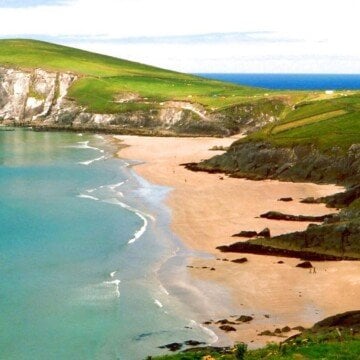 A sandy beach beside blue ocean waters