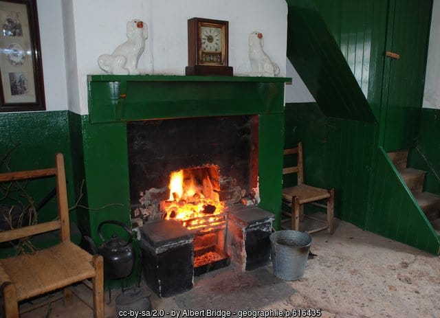 A fire place sitting in a living room filled with furniture 