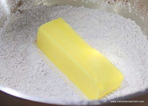 A stick of butter in powdered sugar and cocoa