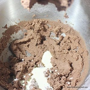 Chocolate buttercream with a splash of cream in a silver bowl