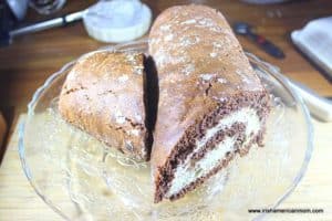 A chocolate swiss roll with a piece cut off to form a log shape