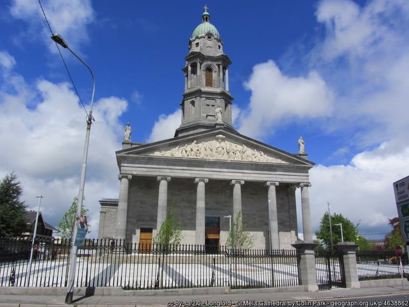 A clock tower on a church with tall pillars