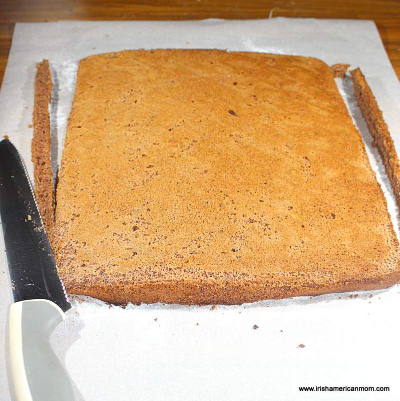 A chocolate cake on a cutting board with a large knife