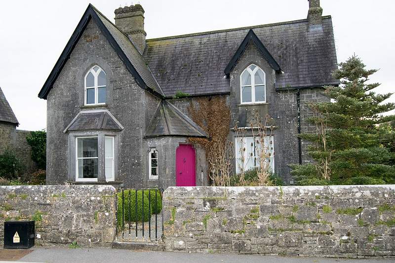 A stone house with a pink door