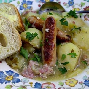 Dublin coddle sausage stew served in a bowl with crusty buttered bread