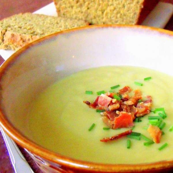 Traditional Irish potato and leek soup in a brown rimmed bowl served with sliced Irish brown bread.