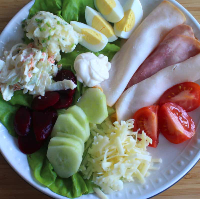 An Irish style salad often called an Irish pub salad | Irish American Mom What to include in an Irish salad meat, tomato, lettuce, boiled egg, cucumber, beets, coleslaw, grated cheese and mashed potato salad