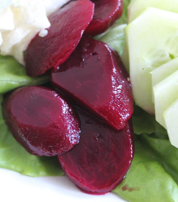 Slices of pickled beets on an Irish pub salad plate | Irish American Mom Sliced pickled beets are placed beside cucumber on an Irish salad plate.