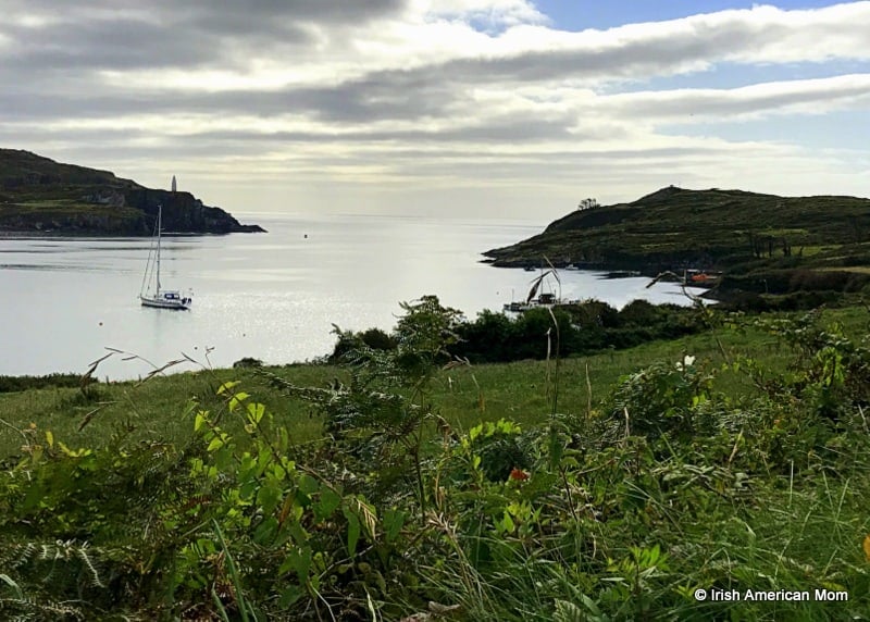 Boat in the bay off the coast of Sherkin Island | Irish American Mom A close up of a hillside next to a body of water