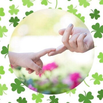 Mother and child touching fingers with a shamrock background