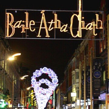 Illuminated text sign over a street in Dublin at night