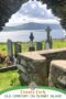 Old cemetery on Dursey Island with stone walls, Celtic crosses, and gravestones overlooking the ocean and mountains in County Cork, Ireland.
