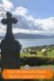 Celtic cross overlooking green fields with sheep grazing and ocean views on Dursey Island in County Cork, Ireland.