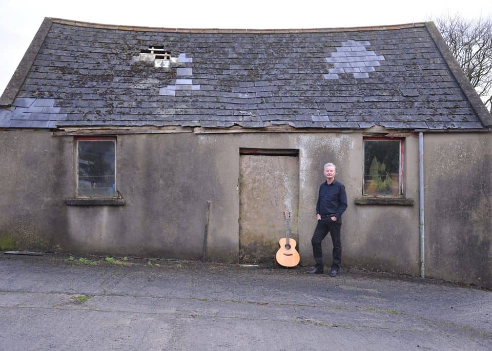 John Lindsay Irish singer and songwriter | Irish American Mom A person standing in front of a brick building
